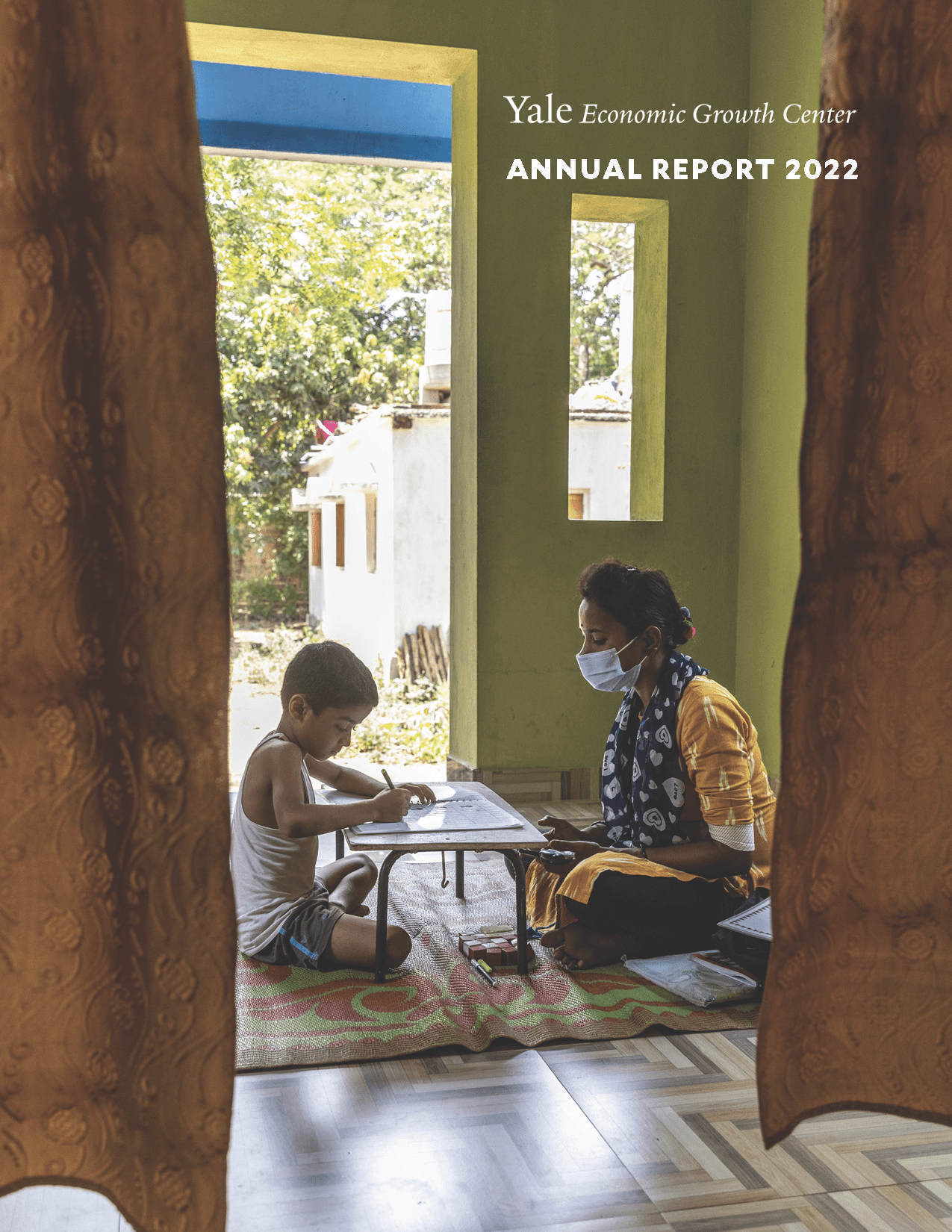 "The cover of the 2021-22 Annual Report features a teacher tutoring a young boy"