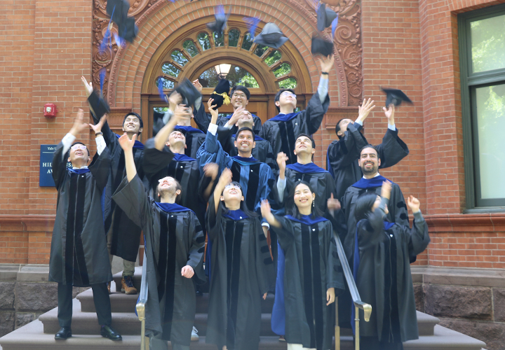 the Class of 2024 throwing their graduation caps in the air outside 28 Hillhouse Ave