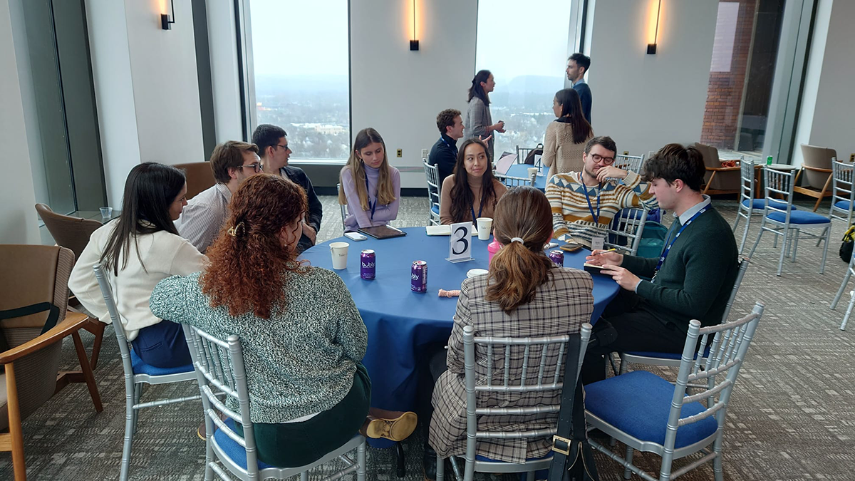 A group of conference attendees discuss ideas at a round table