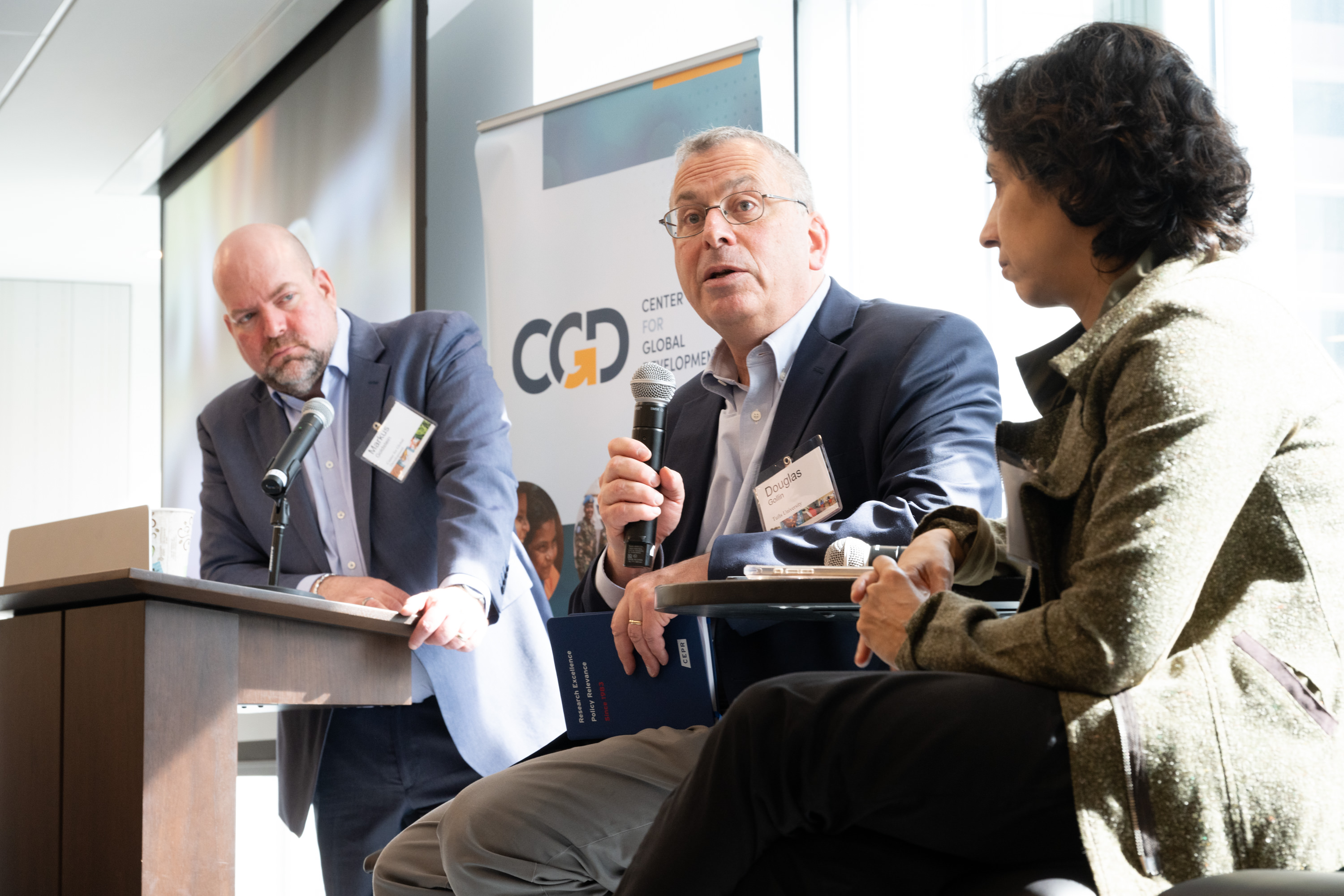 A man in a dark jacket responds to a question during a panel discussion
