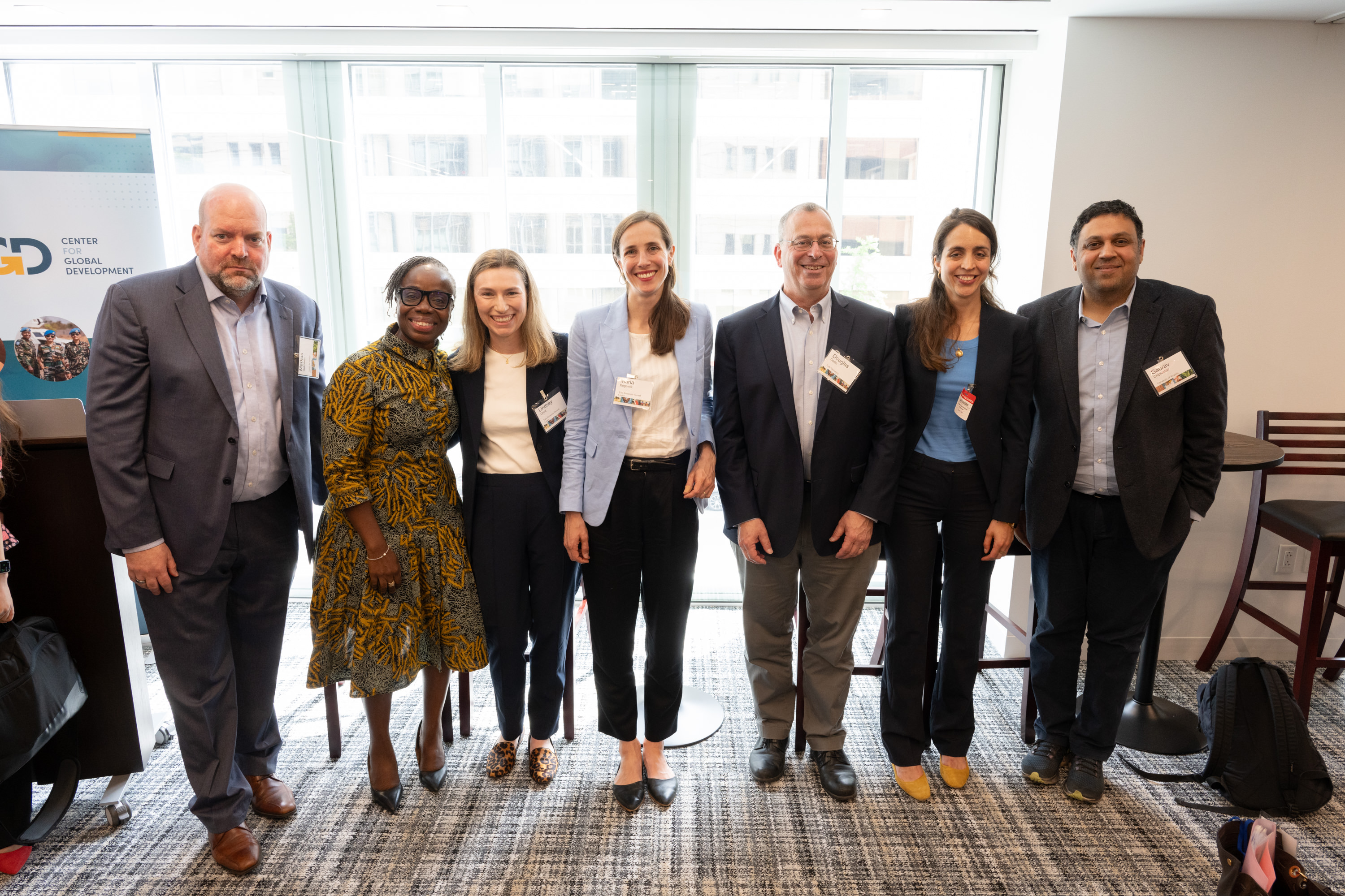 A group of speakers pose at the end of an event
