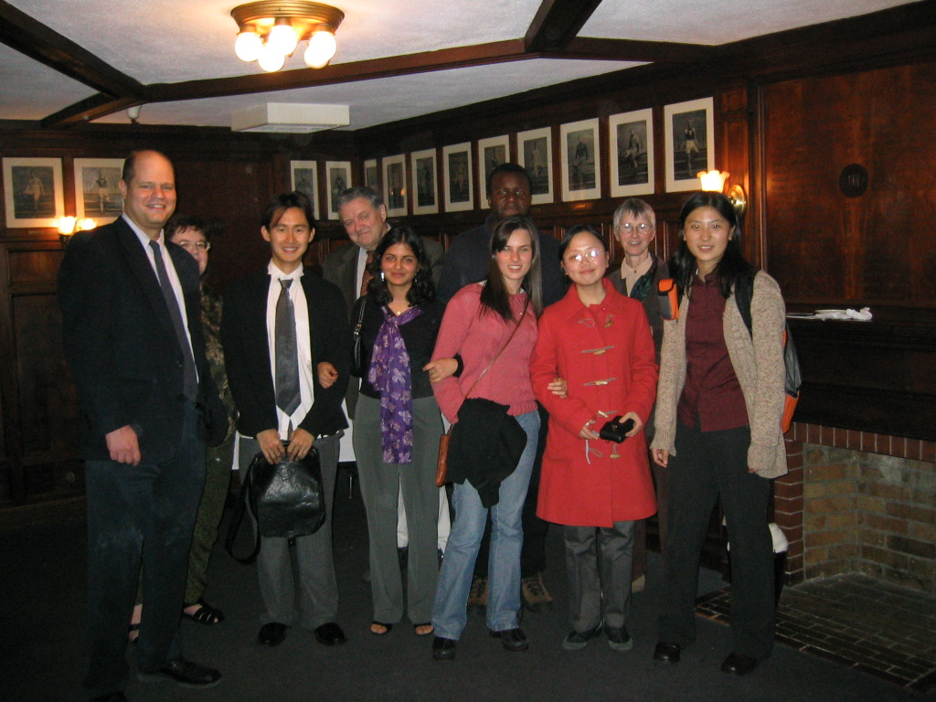 A group of professors and students pose after a dinner