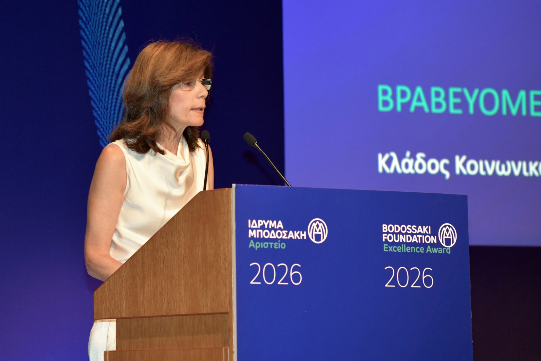 A woman in a white shirt at a podium