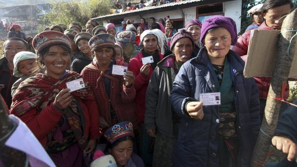 Women holding their voter registration cards