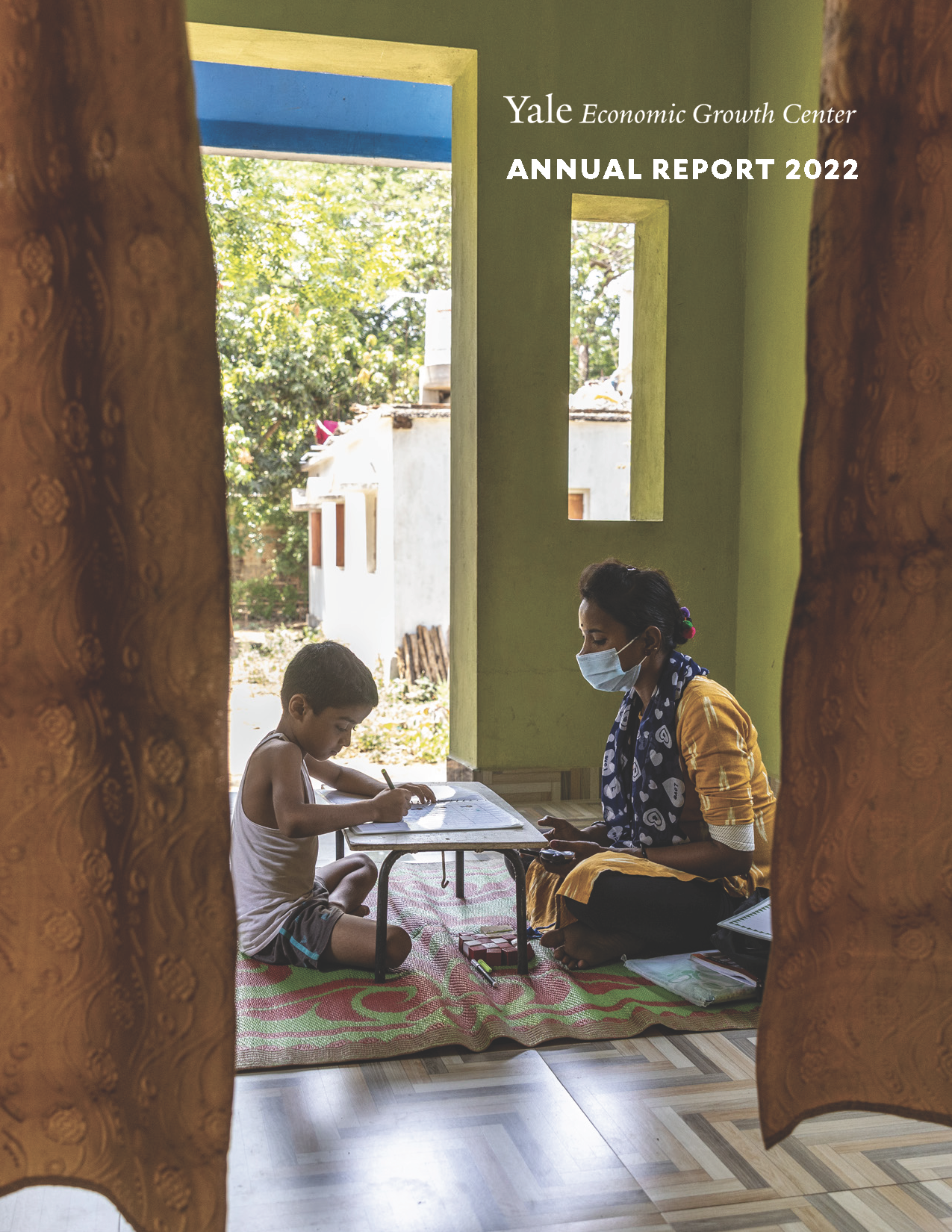 The cover of the EGC Annual Report, showing a teacher tutoring a student