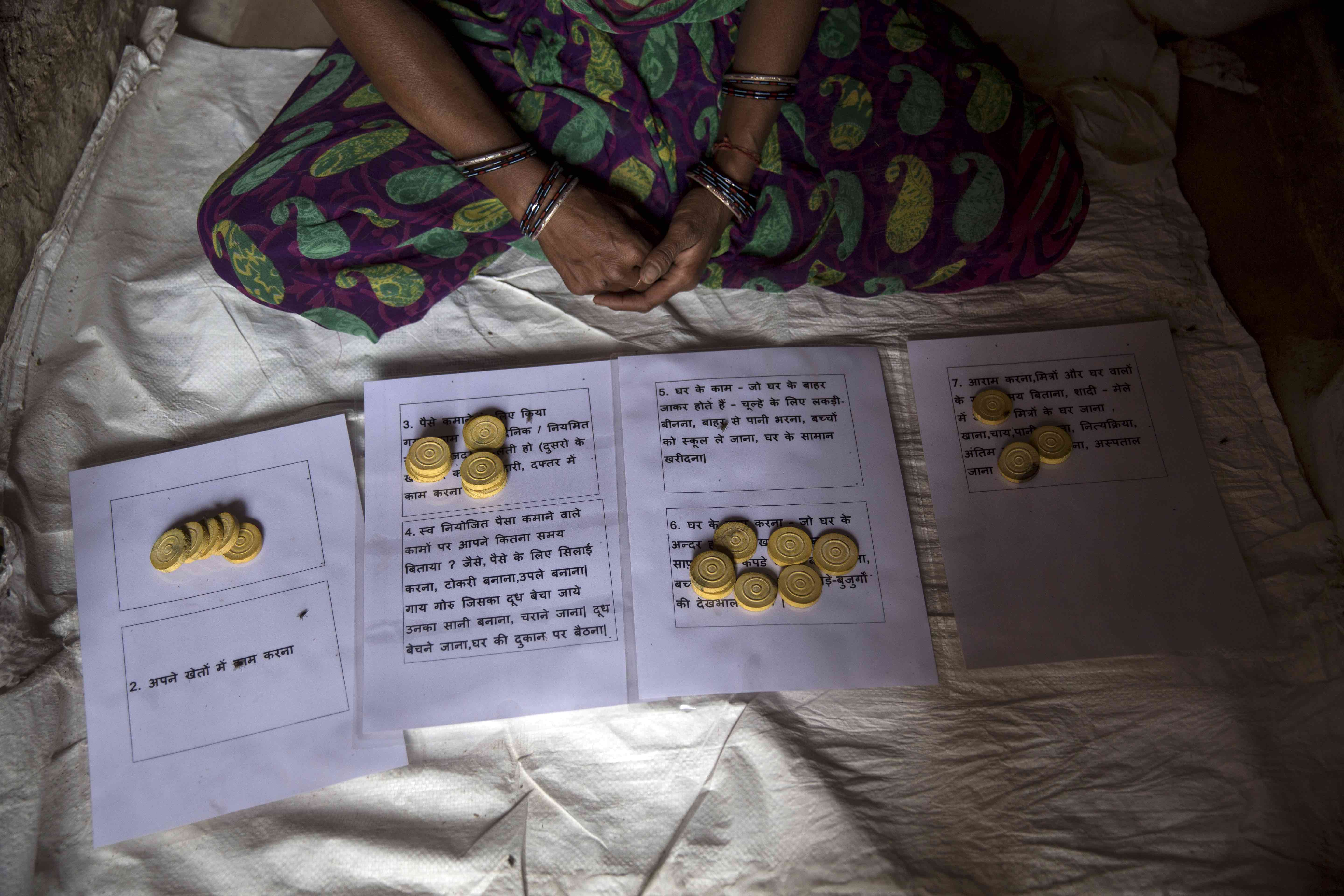 A woman survey respondent places coins onto a mat with separate boxes for anwers.