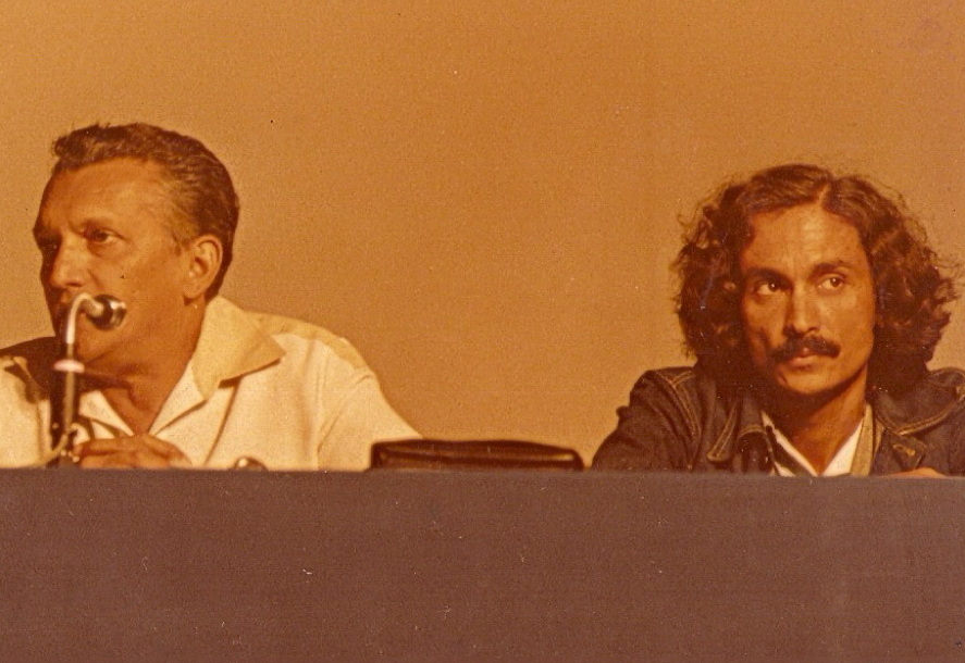 Two men sitting on a panel.