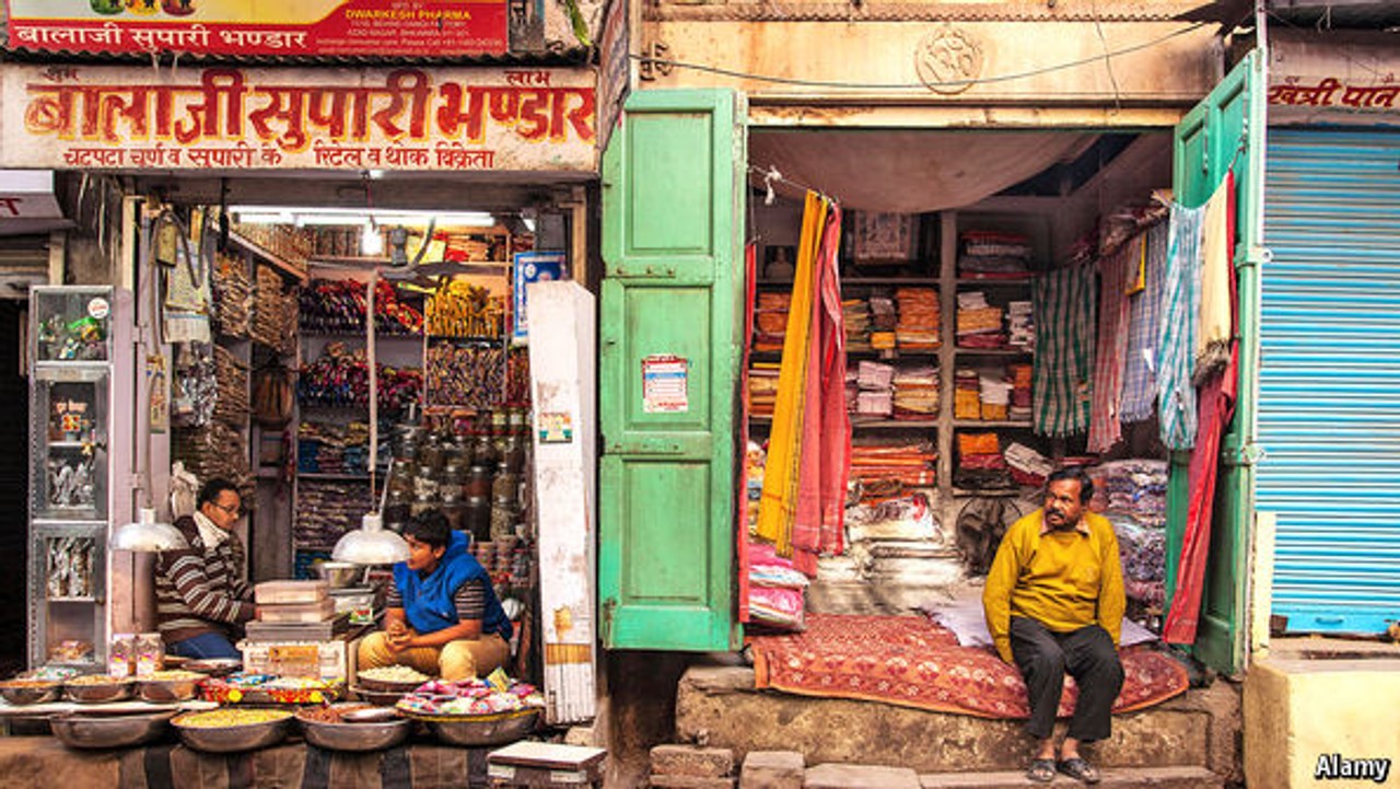 Photo of vendors sitting in front of their small shops