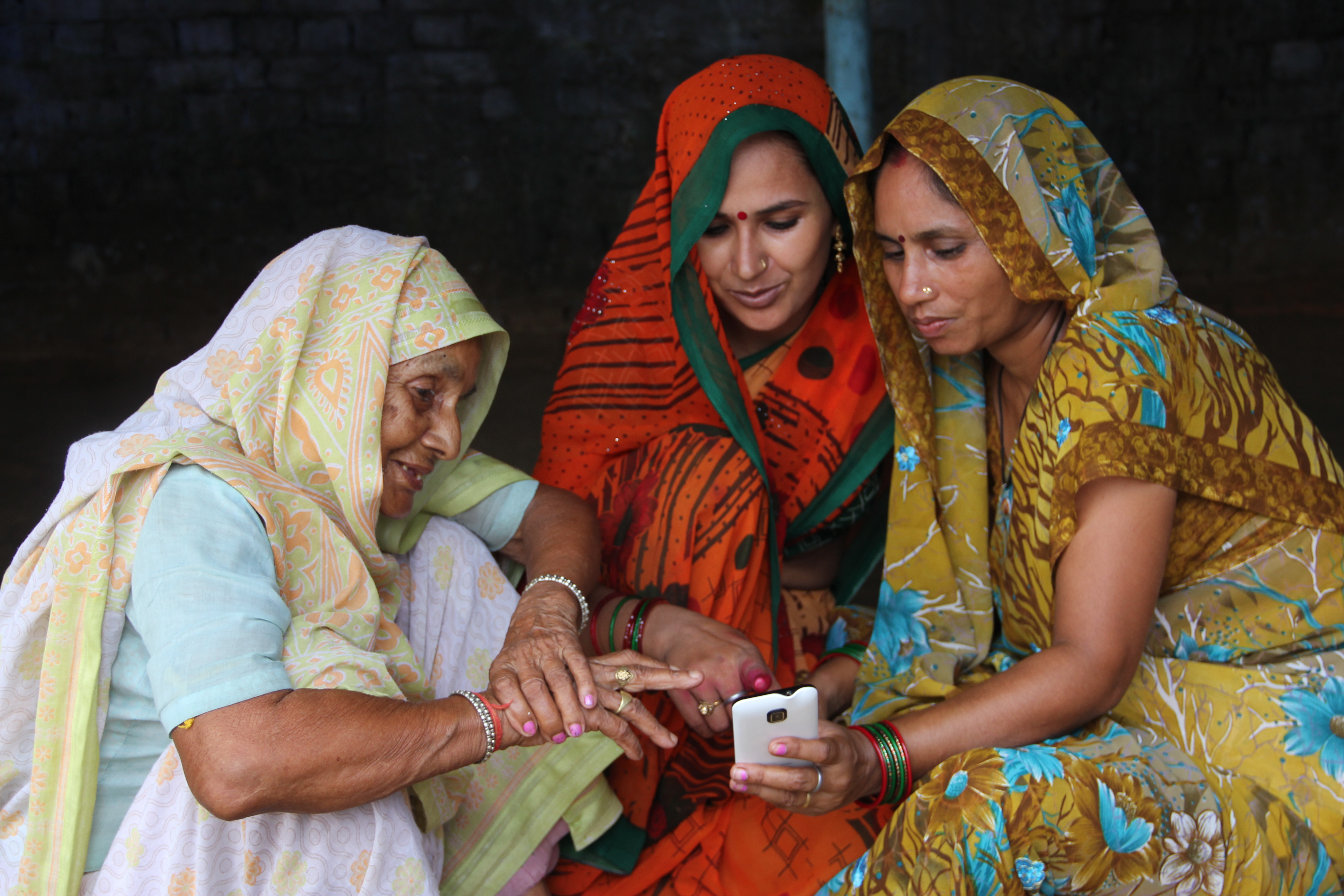 Three women using a mobile phone
