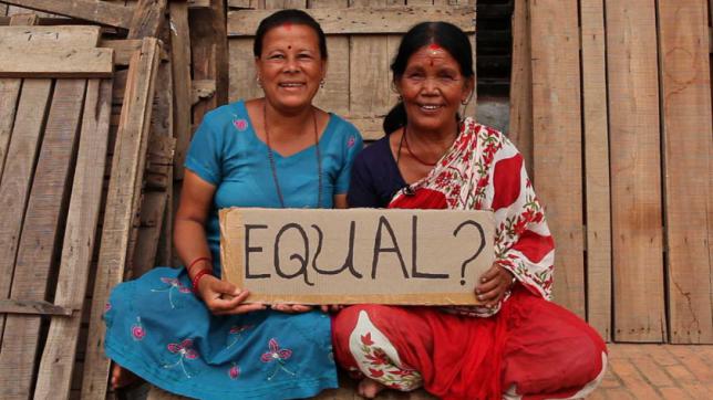 Women holding a sign that reads "Equal?"