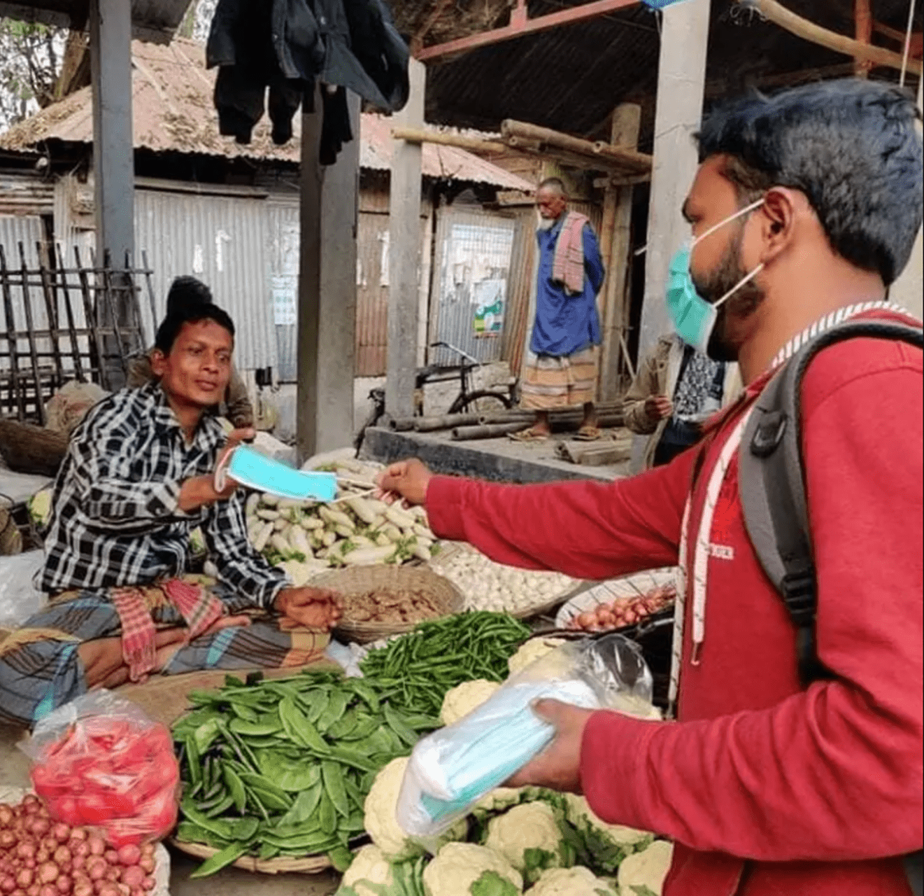 A worker distributes masks at a market