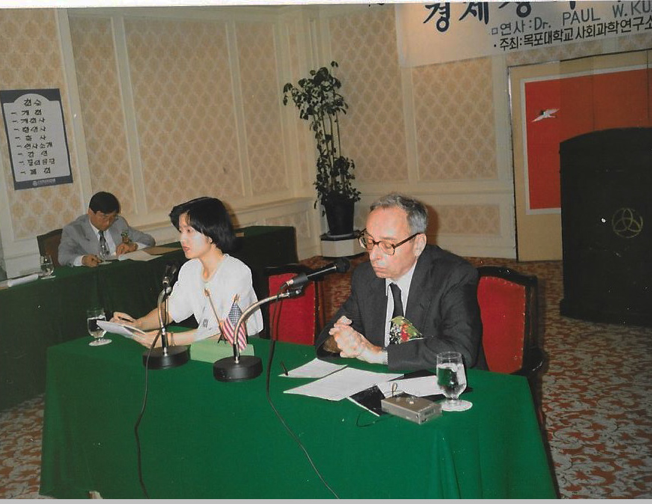 Paul Kuznets and a woman sitting at a table with microphones