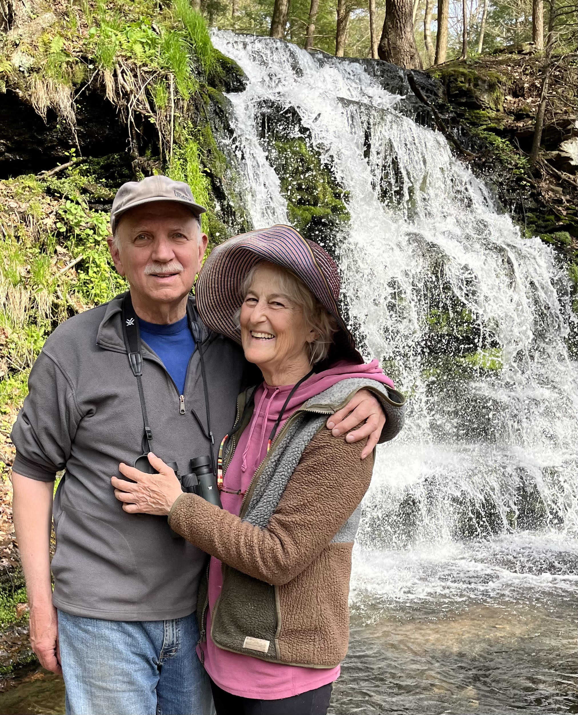 "Folbre stands in front of a waterfall with her partner"