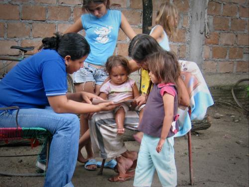 Two women show a small girl some educational toys.
