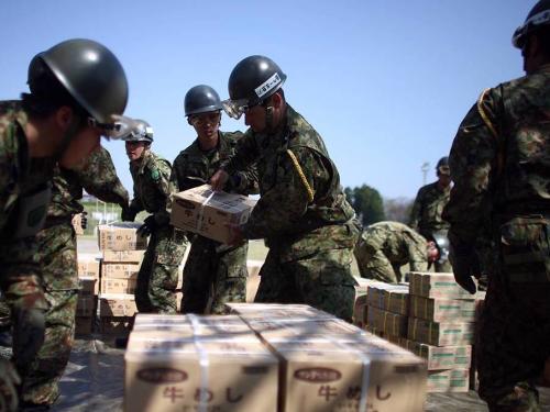 Japanese soldiers work with relief aid packages.