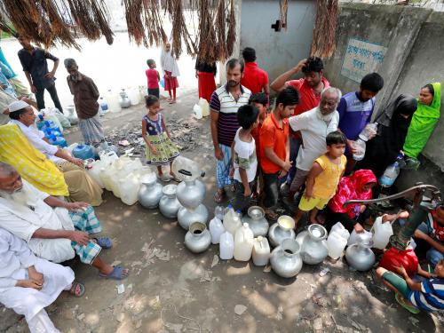 image of Bangladeshi citizens lined up to collect water from a well