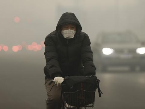 Image: Man on bicycle wearing a surgical mask