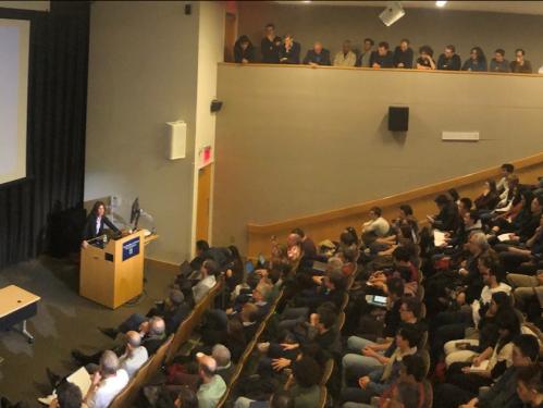 Goldberg delivering a lecture to a full auditorium