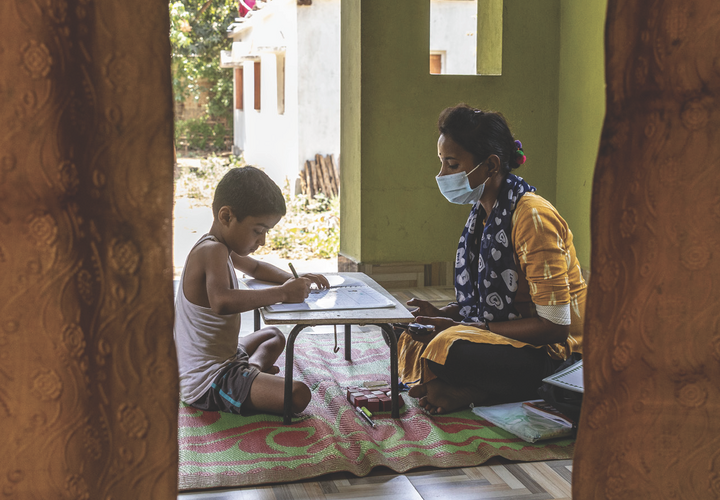 The cover of the EGC Annual Report, showing a teacher tutoring a student