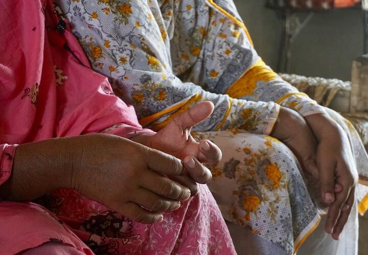 Image of the hands of two women who are sitting. 