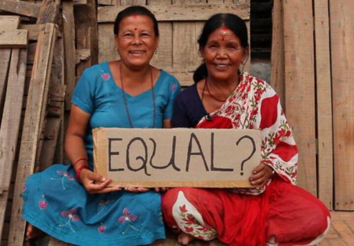 Women holding a sign that reads "Equal?"