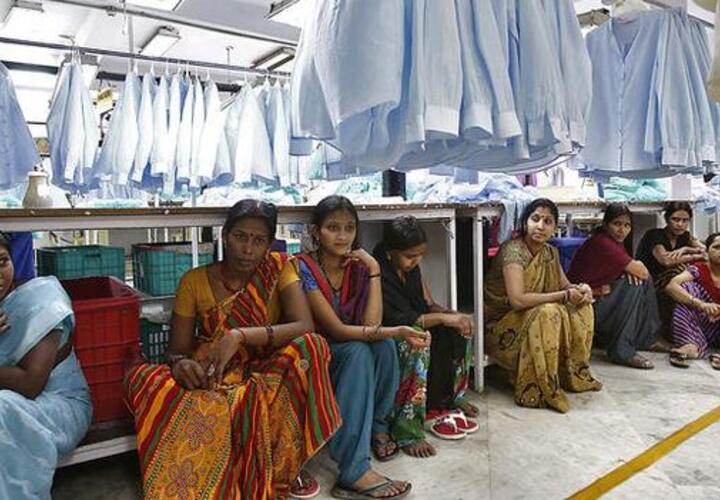 Women in sitting on floor of a laundry facility.