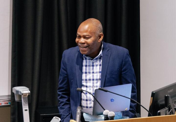 Photo of Leonard Wantchekon smiling while he delivers the Kuznets Lecture.