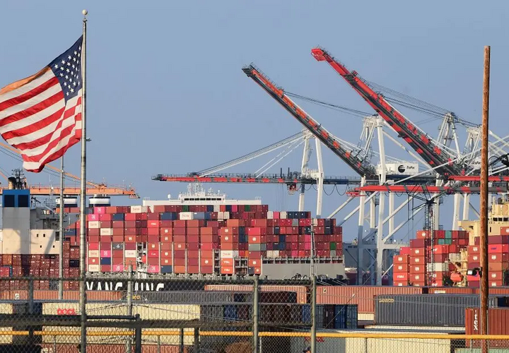 A American flag in the foreground of a shipping port