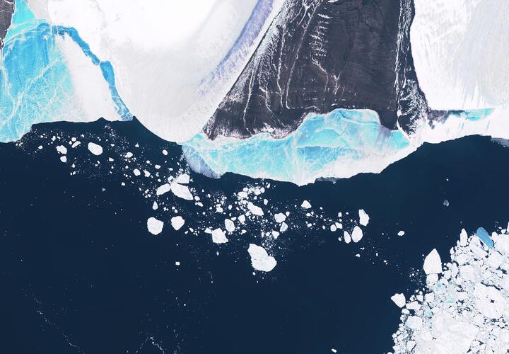 Satellite view of an Antarctic ice shelf fragmenting into icebergs.