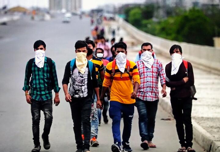 Men with face masks walking down a highway.