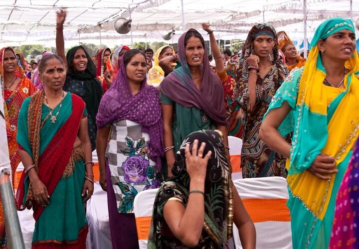 A group of women attend a village assembly meeting.
