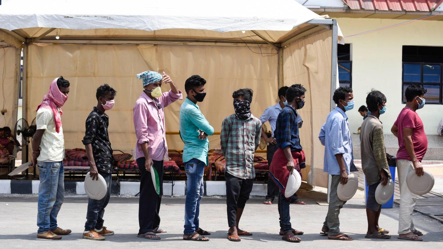 Migrant workers line up to receive food